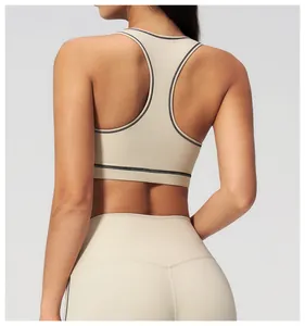 Detail view of beige yoga bra with racerback design and black contrast stitching seams