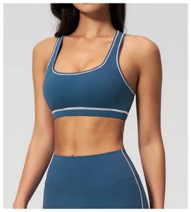Detail of dark blue sports bra with white piping and square neck on high elastic fabric