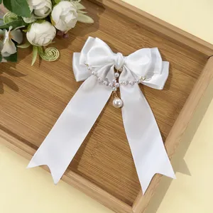 Vista dettagliata dell'elegante fiocco in raso bianco con nappe e pendente di perle