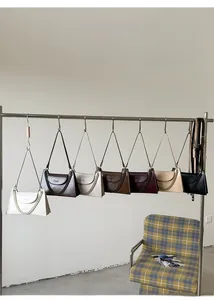 Close-up of stylish faux leather chain bags in seven colors displayed on a metal rack
