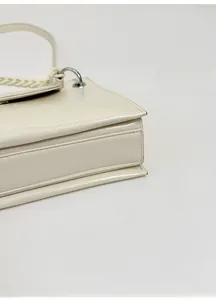 Detailed view of structured bottom and fine stitching on a cream leather bag