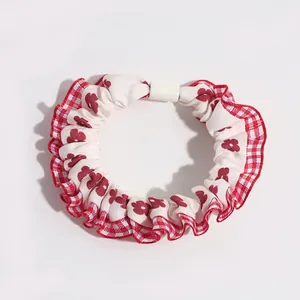 Elastic fabric scrunchie with red plaid edges and floral print pattern