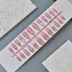 Detail of pink gradient press-on nails with 3D embossed flowers and pearl accents