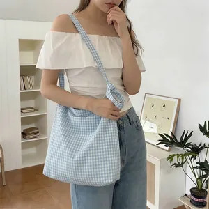 Detailed shot of large blue plaid canvas tote bag with a knotted shoulder strap