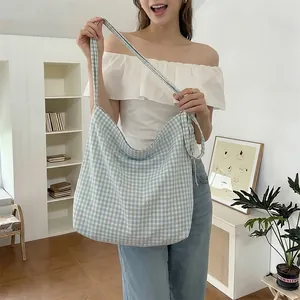 Close-up of a large blue gingham canvas tote bag with wide straps for casual daily use