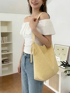 Yellow and white gingham canvas tote bag with a knotted strap shown on a model