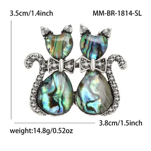 Retro cat brooch with abalone shell and grey rhinestones on a white background