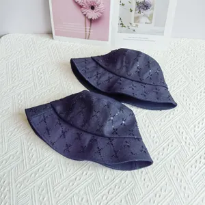 Close-up of two navy denim bucket hats with sequined diamond quilting pattern
