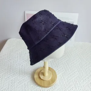 Macro shot of dark blue denim bucket hat with quilted black sequin diamond pattern