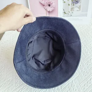 Detail showing the inner black lining and reinforced stitching on a denim bucket hat