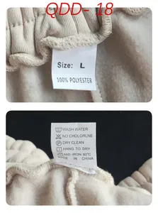 Detailansicht der Etiketten mit 100% Polyester Material und Pflegehinweisen für Hosen