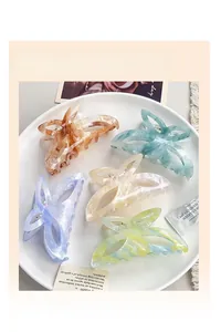 Gros plan de cinq pinces à cheveux papillon colorées dans un plateau chic et élégant