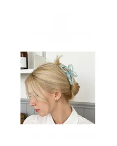 Détail d'une pince à cheveux papillon bleu clair portée sur un chignon de cheveux blonds
