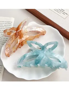 Gros plan détaillé de grandes pinces à cheveux papillon en ambre et bleu marbré