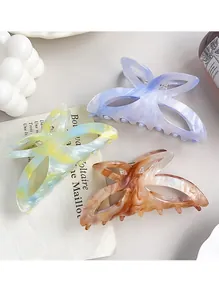 Vue détaillée de grandes pinces à cheveux papillon en acétate aux motifs marbrés