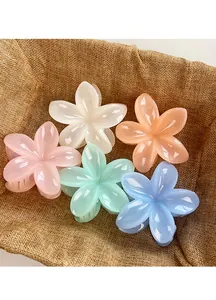 Macro shot of colorful plastic flower hair claws in a rustic basket for styling