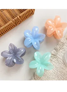 Close-up of pastel flower hair claws in purple blue pink and green gloss resin