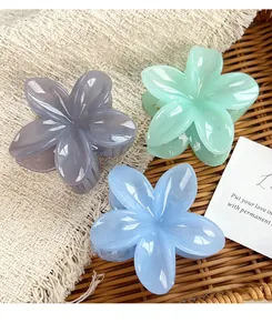 Detail of three pastel flower hair claws in purple, mint green, and sky blue colors