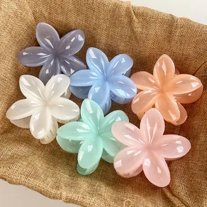 Set of six colorful flower hair claws in candy colors displayed in a rustic basket