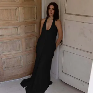 Detail of elegant black deep V-neck halter maxi dress with flowing pleated fabric texture