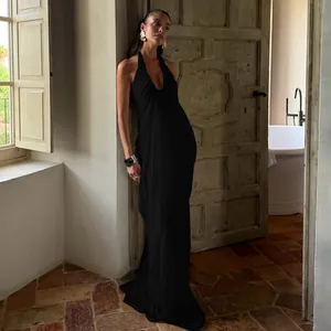 Detail of elegant black backless halter dress with deep V-neck and flowing long skirt