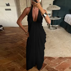 Detail of elegant black deep V-neck halter maxi dress with flowing pleated mesh fabric