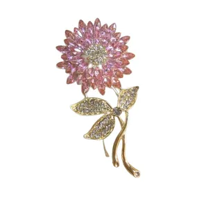 Detailed close-up of a sunflower brooch with pink crystals and golden metal finish