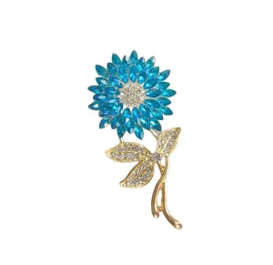 Detail showing blue marquise rhinestones and white crystals on flower brooch