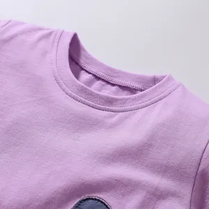 Détail du col rond côtelé sur un t-shirt violet en pur coton pour petites filles