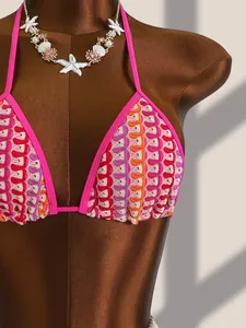 Détail du haut de bikini au crochet coloré avec bretelles roses et motifs de vagues
