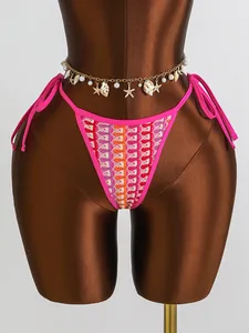 Détail du bas de bikini au crochet coloré avec bord rose et chaîne de taille en coquillages