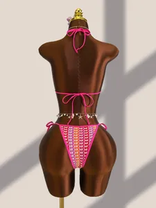 Détail du bas de bikini rose fluo avec motif au crochet coloré et breloques coquillages