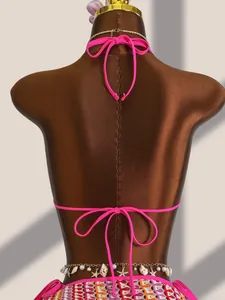 Détail du dos du bikini rose néon avec bordures au crochet et chaîne de taille coquillage
