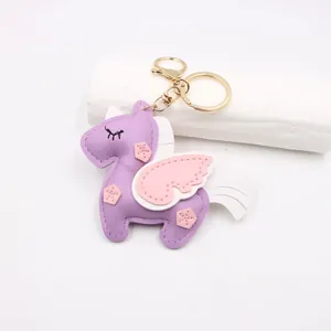 Close-up of purple leather unicorn keychain with gold metal ring and star details