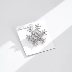 Luxury silver snowflake brooch with sparkling cubic zirconia on a jewelry card