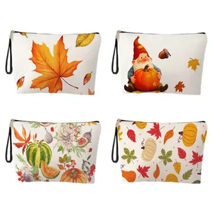 Fall themed makeup bags featuring autumn leaves and pumpkins with black wrist strap
