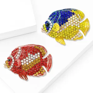Eleganti spille a forma di pesce tropicale con strass rossi e blu su base bianca