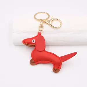 Close-up of red PU leather dachshund bag charm with gold metal hardware and stitching