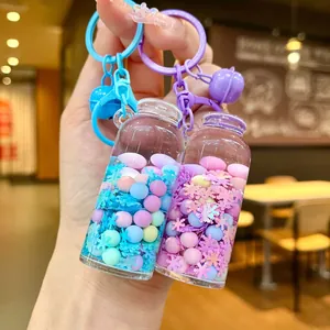 Close-up of pastel drift bottle keychains with colorful beads and small bells
