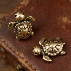 Macro shot of two vintage brass turtle figurines with detailed heart shell patterns