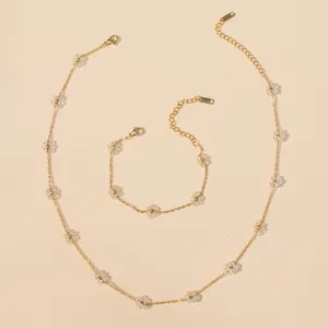 Macro shot of stainless steel necklace and bracelet set with crystal flower charms