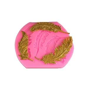 Pink silicone feather mold for baking and DIY crafts with golden feather samples