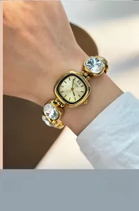 Close-up of GEDI quartz watch featuring crystal-encrusted gold bracelet and textured dial