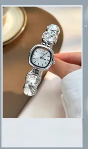 Detail view of silver luxury watch featuring cushion-cut crystal chain and quartz dial