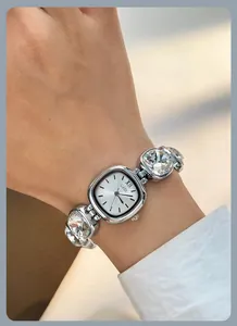 Detailed view of silver GEDI watch with large crystal links and square dial on wrist