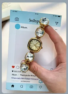 Detailed shot of a luxury gold quartz watch with a square dial and crystal bracelet