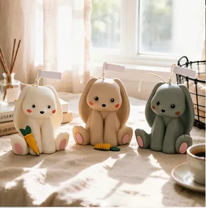 Three cute 3D bunny scented candles in neutral tones placed on a soft linen surface
