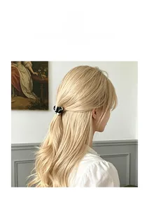 Gros plan sur une pince à cheveux cœur en acétate avec motif de vache