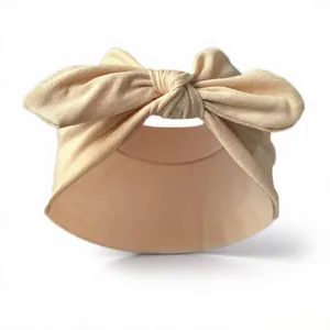 Detail of soft peach knit fabric baby headband with a large handmade knot bow