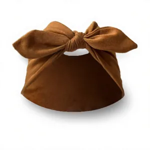 Detailed view of caramel brown knit elastic baby headband with large bow tie knot